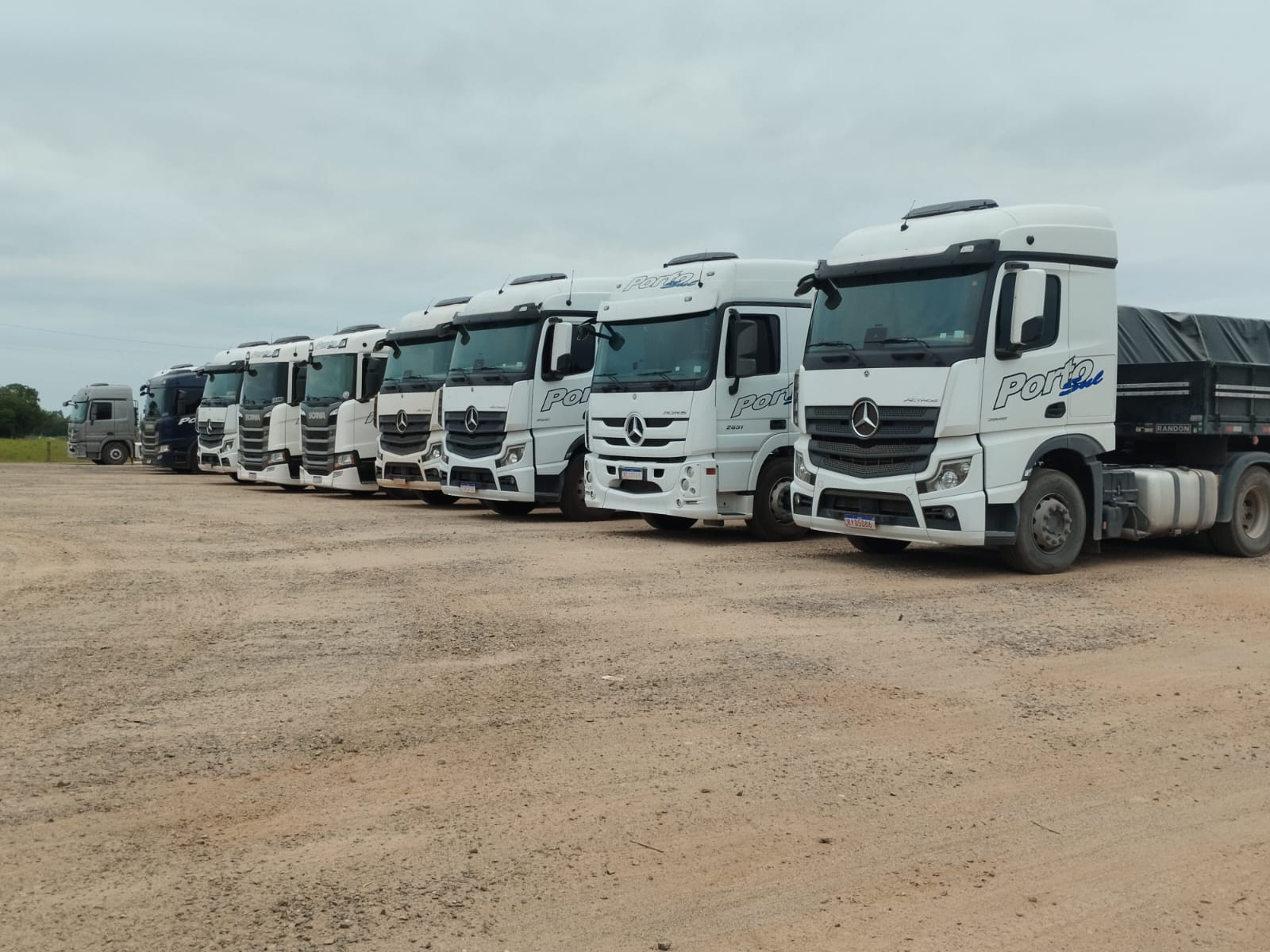Frota própria da Porto Sul Transportes enfileirada, caminhões Mercedes-Benz e Scania